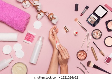 Make-up Remover Accessories. Flat Lay Background Womens Hands Try Cosmetics, Cotton Branch, Cotton Pads, Cosmetic Bottle Containers, Pink Towel, Various Make-up Cosmetics, Mascara, Powder, Lipstick.