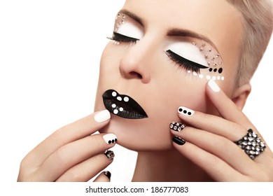 Makeup with rhinestones and manicure in black and white colors on the girl 