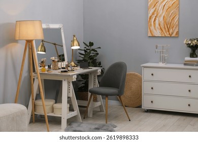 Makeup room. Mirror, dressing table, different beauty products and chair indoors