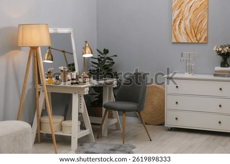Makeup room. Mirror, dressing table, different beauty products and chair indoors