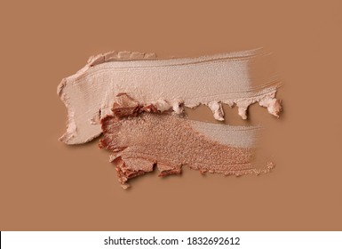 Make-up shimmer mousse foundation concealer bronzer and highlighter smudge creamy powder on beige background