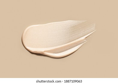 Make-up shimmer mousse foundation concealer highlighter smudge creamy powder on beige background