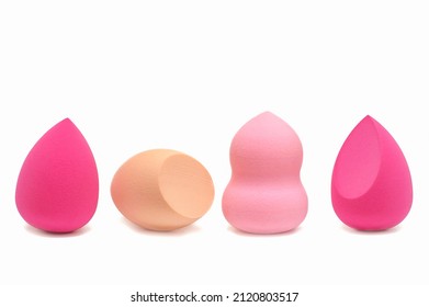 Makeup sponges of different colors and different shapes on a white background