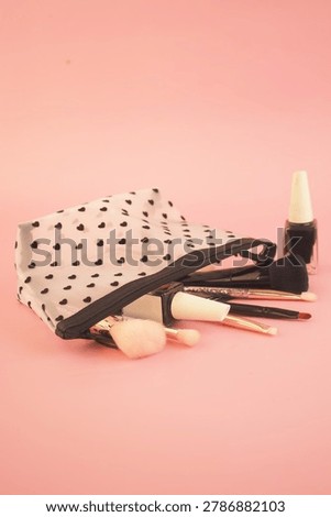 Makeup tools and bag on a pink background