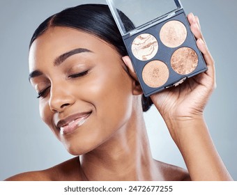 Makeup, woman and eyeshadow palette in studio grey background for facial beauty and cosmetics. Smile, Indian female person and blush in hand isolated against backdrop for skincare and dermatology - Powered by Shutterstock