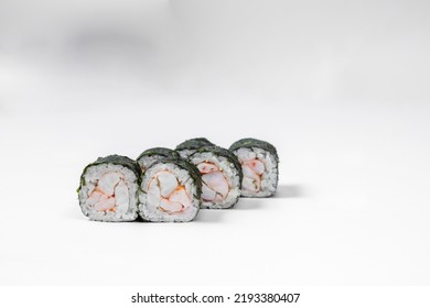 Maki shrimp sushi. Shrimp fillet stuffing wrapped in rice and nori seaweed. Sushi stands on a white background.