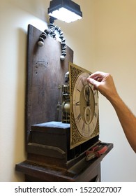 Making adjustments to an antique grandfather clock