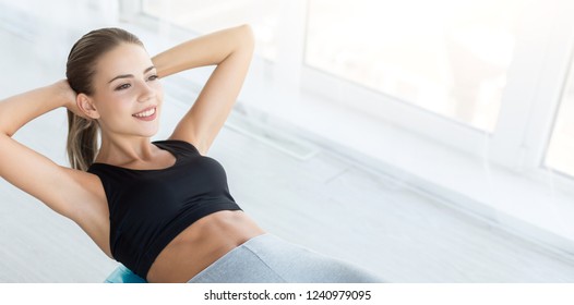 Making beautiful belly. Smiling woman working out with fitness ball, doing exercises for muscle press, panorama, copy space