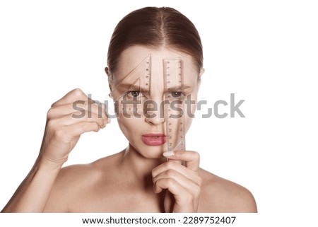 Making beauty, modifying face to make non-surgical or surgical correction, plastic surgery. correction of asymmetry. Young woman, female patient isolated on white studio background. Concept of lifting