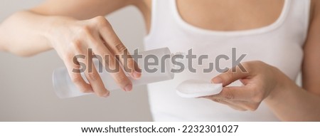 Making beauty routine, hand holding cotton pad and bottle, young woman applying facial wipe on her face remover washing makeup, essence or lotion of skin care treatment, isolated on white background.