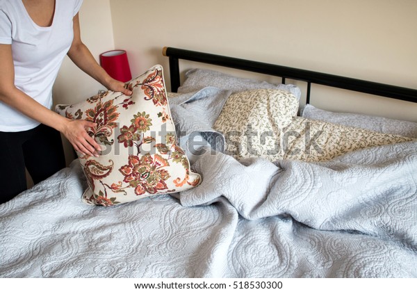 Making bed room service.\
Close up of hands making bed in a bedroom. Woman beheaded bed.\
Woman making bed