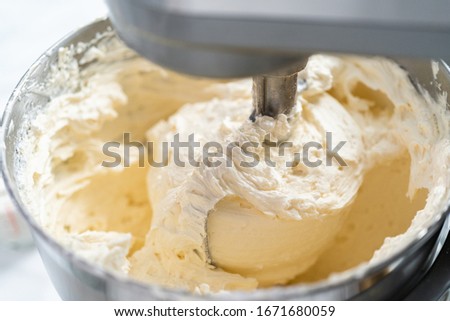 Making buttercream frosting for decorating a vanilla cake.