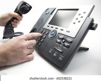 Making a call, man is dialing IP telephone keypad