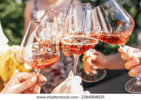 Making a celebratory toast with sparkling wine. Female hands holding glasses of rose champagne. Birthday, holiday, party and friendship concept. Stock foto © 