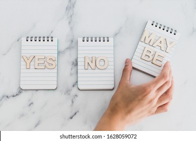 making a choice and facing doubts conceptual still-life, notepads with Yes No and Maybe options 