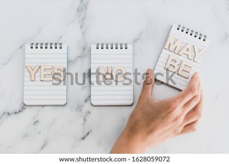 making a choice and facing doubts conceptual still-life, notepads with Yes No and Maybe options 