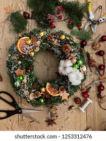 Making Of Christmas Wreath. Christmas Wreath On Wooden Table Top View. Top Down View Of Florist`s Worktable. Getting Ready For Christmas.