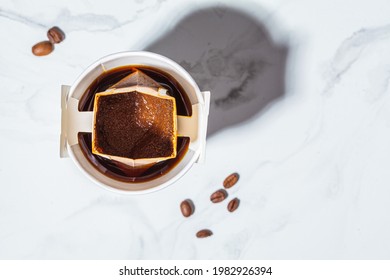 Making Coffee With Drip Coffee Bag In A White Paper Cup, Top View. Drip Brewing Coffee.