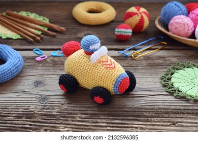 Making colored crochet racing car. Toy for babies and toddlers to learn mechanical skills and colors. On the table threads, needles, hook, cotton yarn. Handmade crafts. DIY concept. - Powered by Shutterstock