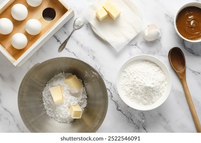 Making cookies and corn starch alfajores. Eggs, butter, corn starch, powder sugar, baking powder, and dulce de leche on a white marble background. - Powered by Shutterstock