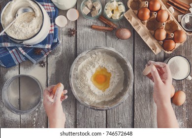 Making dough top view. Overhead of baker hands with broken eggshell. Eggs and flour in a bowl. Cooking ingredients for pastry on rustic wood, culinary classes or recipe concept. - Powered by Shutterstock