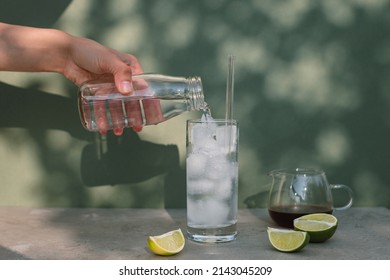 Making Espresso Tonic. Pouring Tonic Into A Tall Glass With Ice Cubes.