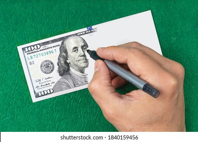 Making Fake Money. Hand Draws A Dollar. Counterfeiting Money. Green Blur Background. Concept