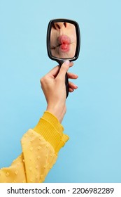 Making Fish Face. Woman's Hands Holding Small Mirror With Reflection Of Female Red Lips Isolated Over Blue Background. Concept Of Vintage, Retro Style, Beauty, Ad.