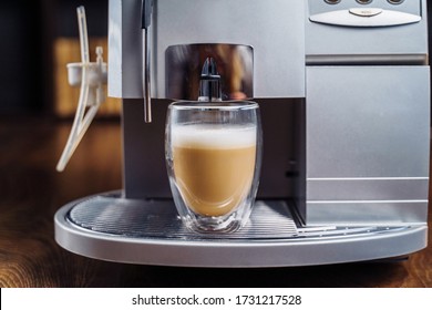 Making Fresh Coffee Going Out From A Coffee Espresso Machine. Making Capuccino In Glass Transparent Coffee Cup. Budget Coffee Maker