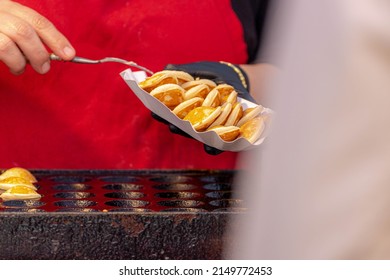 Making fresh poffertjes on market, Traditional Dutch batter treat, Resembling small fluffy pancakes they are made with yeast and buckwheat flour, Poffertjes are popular in the Netherlands.