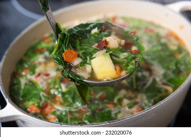 Making Fresh Soup With Baby Greens, Vegetables, And Chicken Bone Broth 