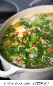 Making Fresh Soup With Baby Greens, Vegetables, And Chicken Bone Broth 