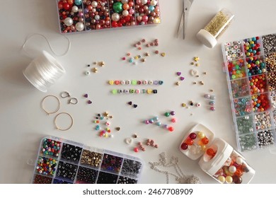 Making friendship bracelets with letter beads. Jewelry making supplies on the table. Flat lay. - Powered by Shutterstock