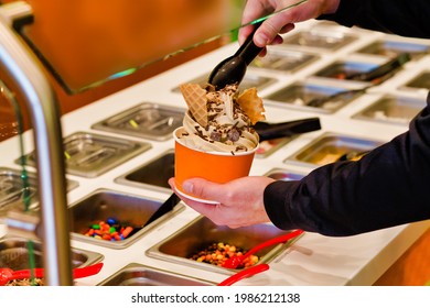 Making Frozen Yogurt With Chocolate Chips And Sprinkles At The Buffet