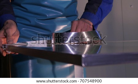 Making the glass. Making the glass for window on manufacture. Glass reinforcied by tape.After grinding worker using reinforcing tape taping the corner of the glass. Industry