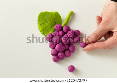 Making grape game step by step with dough for children's activity in the school art lesson and plasticine concept.
