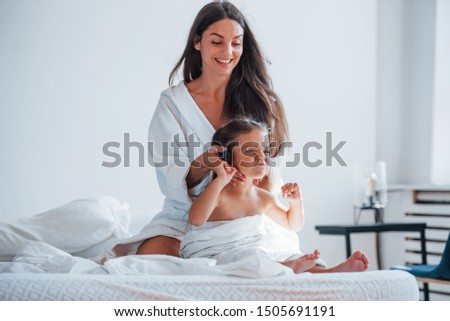 Similar – Relaxed mother and sons playing over the bed