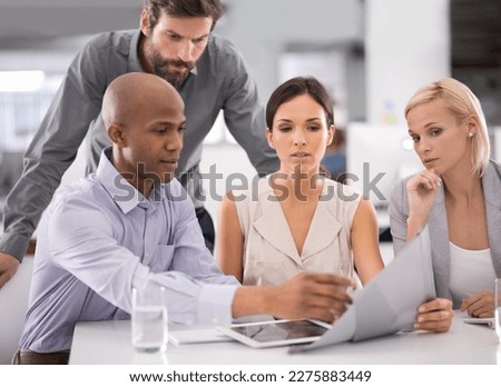 Making headway with their project. a group of businesspeople discussing the contents of a file during a meeting.