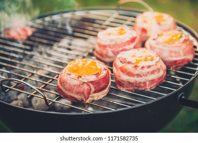 Making Home Made Beer Can Bacon Burgers On Barbecue Grill. Preparing Stuffed Patties, Wrapped  In Bacon And Grilling On Indirect Heat In Nature At Back Yard BBQ Picnic. Low And Slow Technique With Sun