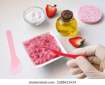 Making homemade face mask of strawberries and rice flour. A woman's gloved hand stirs a cosmetic product with a ceramic spoon. The concept of natural skin care. - Powered by Shutterstock