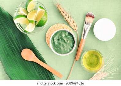 Making Homemade Facial Mask Skin Care Product With Green Clay Powder, Mixed With Lime Wheat Oil In Bowls. Body Detox Treatment Organic Cosmetic. Top View Fresh Green Table Cloth Background.