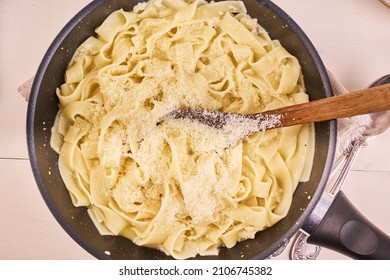 Making Homemade Fettuccine Alfredo Pasta. Fettuccine In A Pan With Sauce And Grated Cheese, Top View, Close-up