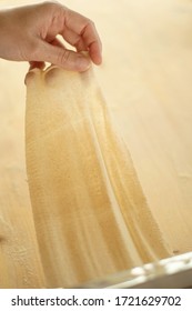 Making Homemade Fresh Pasta: Overhead Top View Backlit Of A Woman Hand Show The Transparency Of The Just Rolled Out Fresh Pasta