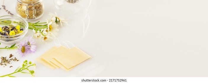 Making Homemade Herbal Tea From Wild Plants And Flowers. Home Herbal Apothecary Concept. Eco Friendly Banner With Natural Flowers And Herbs, Tea Bags On A White Background With Copy Space