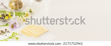 Making homemade herbal tea from wild plants and flowers. Home herbal apothecary concept. Eco friendly banner with natural flowers and herbs, tea bags on a white background with copy space