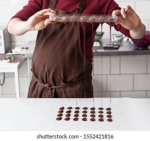 Making homemade praline sweets, liquid chocolate in forms. Close-up view. - Powered by Shutterstock