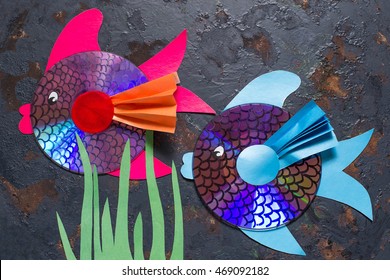 Making homemade toy fish from the CD. Handmade children's project. Step by step photo instructions. Step 8: Two fish made of the CD on a blue wooden background