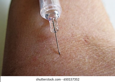 Making an injection on arm - macro photo - Shutterstock ID 650157352