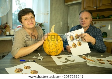Making Jack O'Lantern at home. The process of creating a Jack O'Lantern theme template. A man and a woman are preparing a pumpkin for carving.