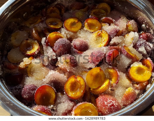 Making\
jam from plums with sugar. Plums are in the\
pan.